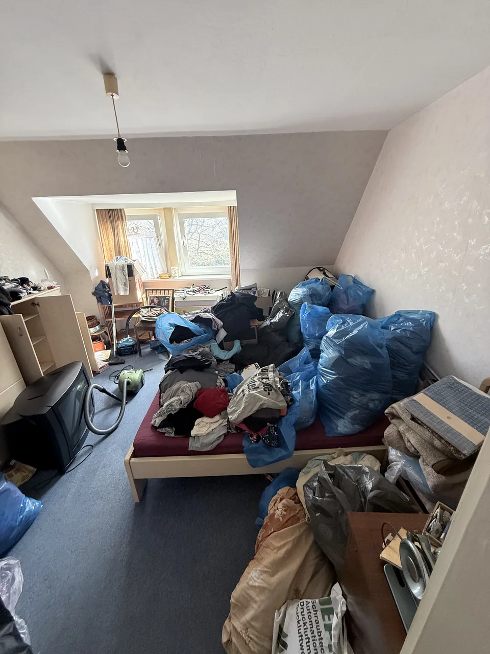 Herzig Dienstleistungen: Möbel, Taschen und Hausrat im Dachzimmer vor der Räumung.