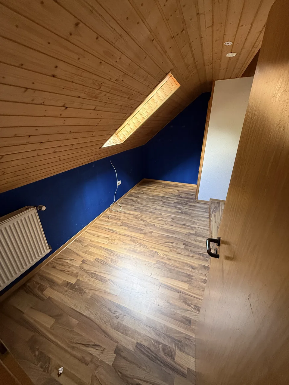 Herzig Dienstleistungen: Der freigeräumte Bereich unter der Holzdecke; die blaue Wand bleibt erhalten.