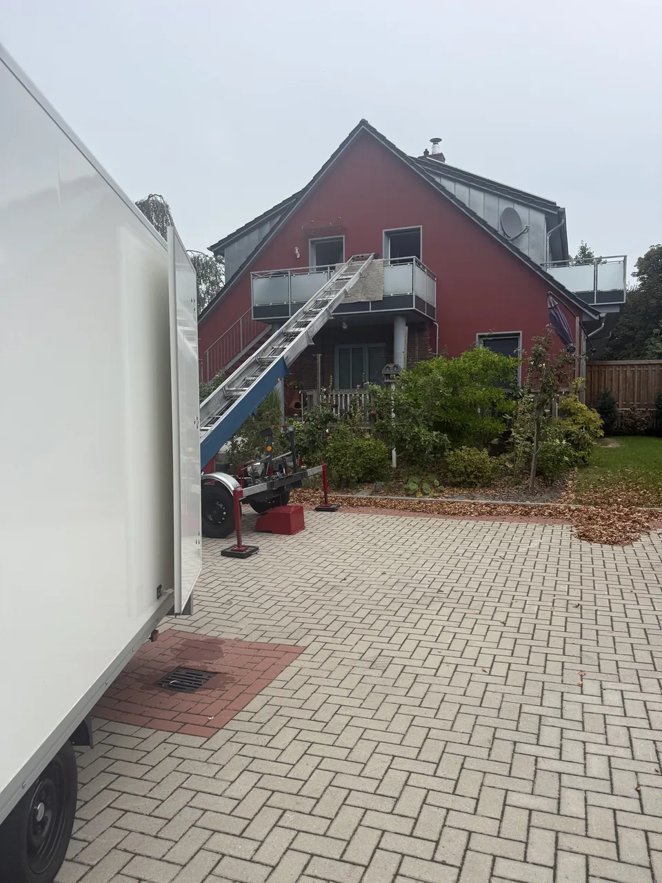 Herzig Dienstleistungen: Der Außenlift ist neben dem Transporter an einem Wohnhaus aufgestellt.