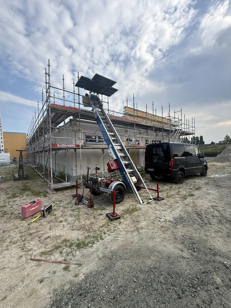 Anhänger-Lift an einem eingerüsteten Gebäude auf einer Baustelle